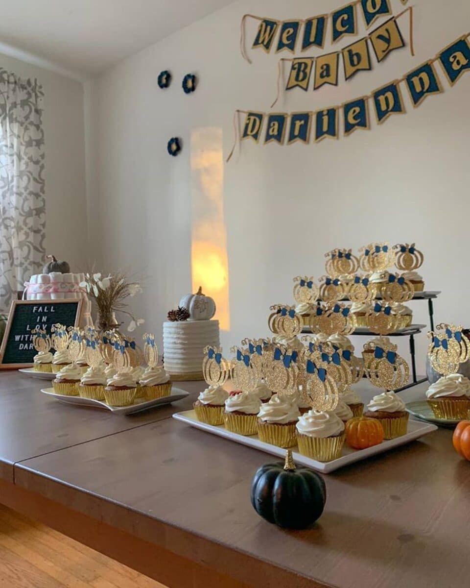 Baby shower dessert table with gold-wrapper cupcakes by Baketastic By Suhey