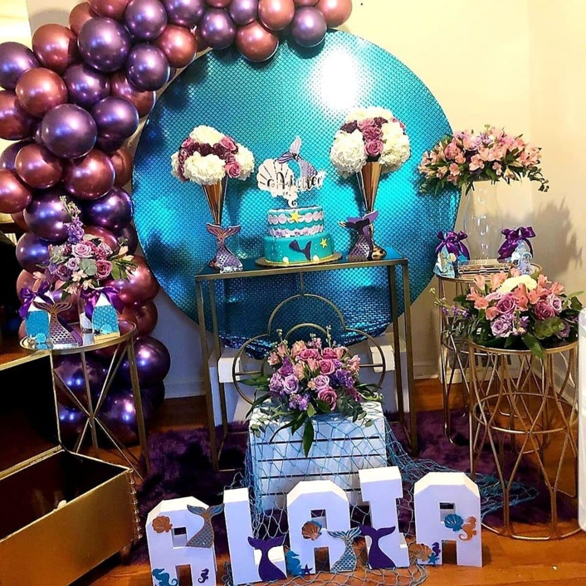 Candy table event setup with purple balloon arch